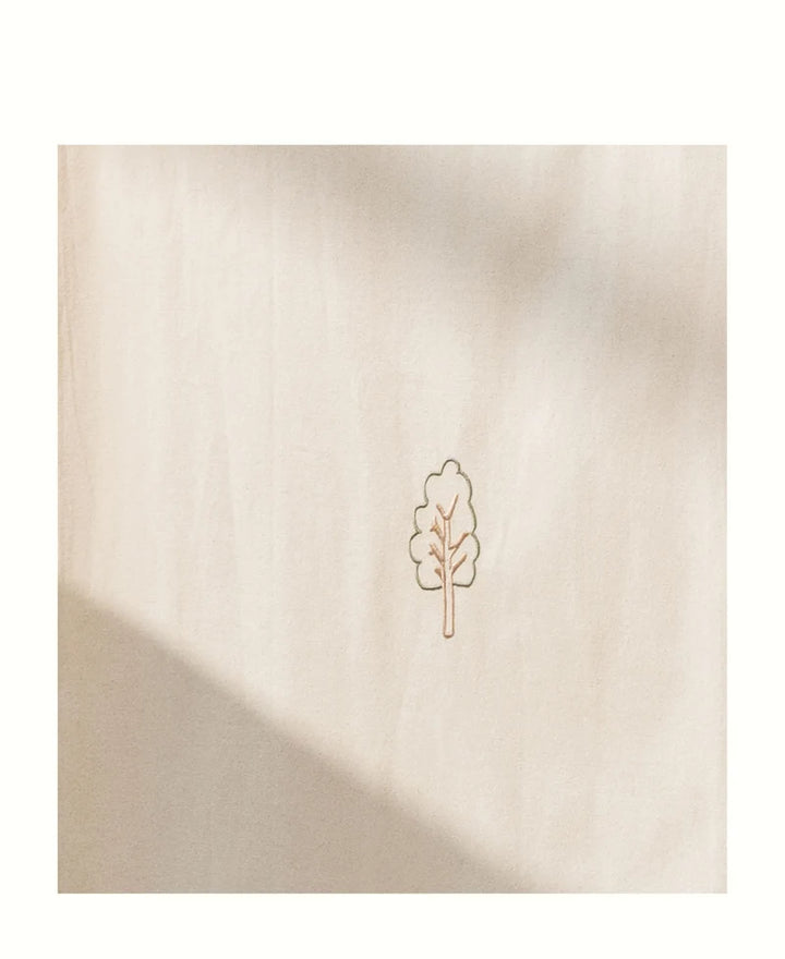 A square beige fabric of the house bed canopy with a small minimalist tree outline printed in the center, shown against a white background with soft shadow overlays.