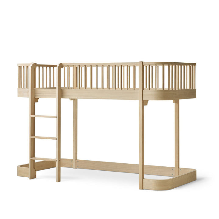 Oliver Furniture Oak  wood loft bed with a built-in ladder, featuring a curved lower base and a matching wooden safety railing on the loft level, shown against a plain white background.