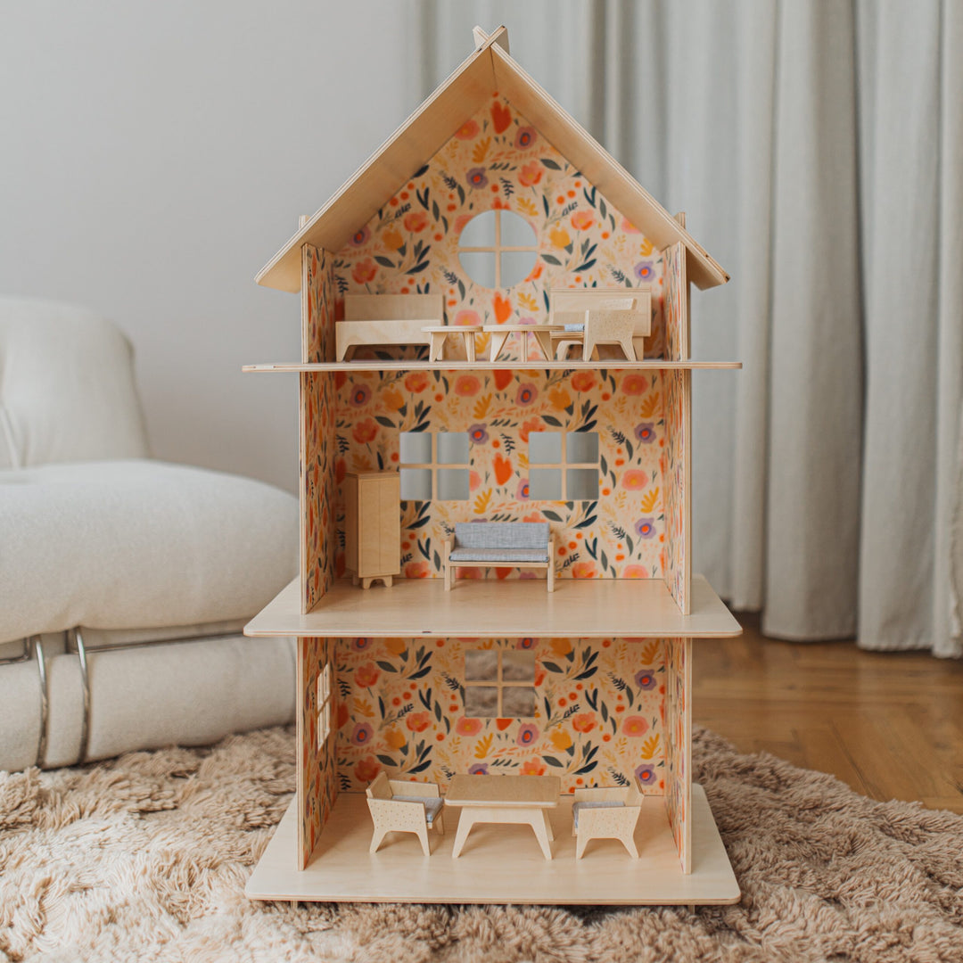 Wooden dollhouse with floral pattern on a rug in a room.